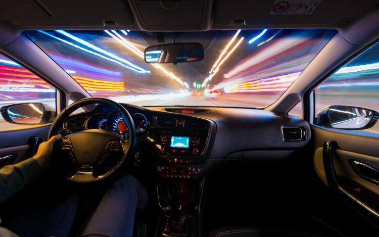 nocna jazda samochodem z włączonymi światłami